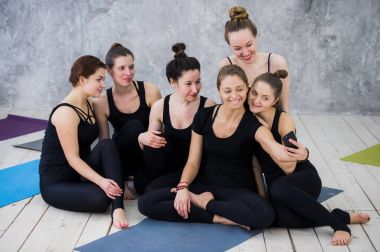Oturan ve uzun yoga dersten sonra rahatlatıcı ve selfie alarak kadın grubu