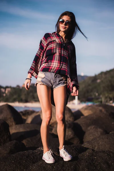 Menina sexy na camisa de flanela na praia rochosa . — Fotografia de Stock