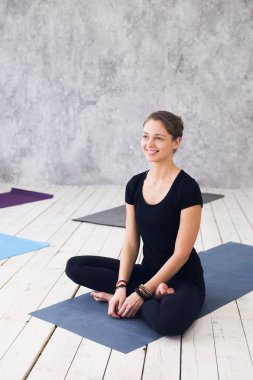 Siyah t-shirt, pantolon, meditasyon yoga sınıf katında oturumunda çalışma dışarı, pratik yoga, Ardha Padmasana egzersiz, yarım Lotus poz, oturan genç çekici kadın giyiyor