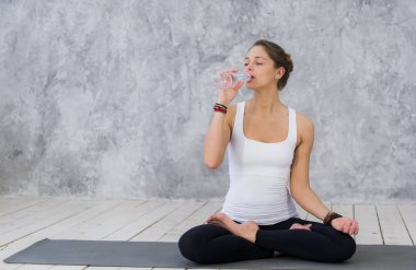 Susuz hissediyorum. Genç kadınlarda yorgun: içme suyu egzersiz mindere otururken giyim spor
