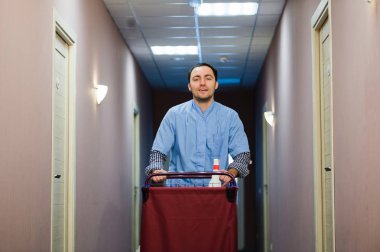 Genç yakışıklı iterek temizlik arabası - otel görüntüleri bir dizi.