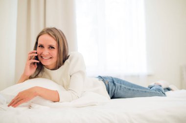 bir kadın, ileri o gülümsüyor gibi arama yapma yatağında yatıyor.