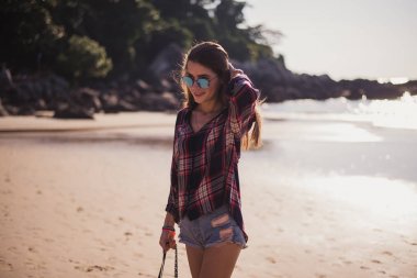 Yaz güneşli yaşam tarzı moda portre hoş trendy elbise, seyahat, doğa yürüyüşleri, gülümseyen giyen kumsalda yürüyen genç şık hipster kadın zevk onu hafta sonları