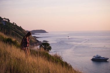 Genç şık hippi kız bakış açısı üzerinde günbatımı keyfini çıkarın. Sırt çantası kadınla seyahat