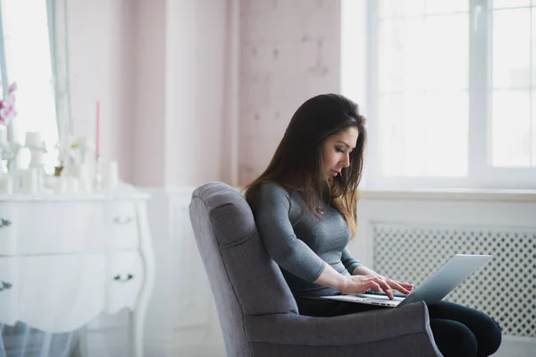 Mooie dame werkt op haar laptop tijdens de vergadering in een leunstoel — Stockfoto