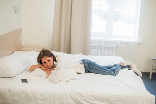 Una mujer acostada en su cama todavía vestida con su ropa para cansarse de meterse en la cama . — Foto de Stock