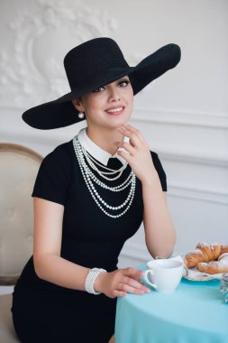 Ünlü oyuncu, çay içme ve yemek yeme kruvasan gibi şapkalı kadın.