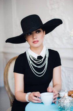 Ünlü oyuncu, çay içme ve yemek yeme kruvasan gibi şapkalı kadın.