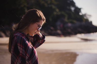 Genç güzel şık kız plajda rüzgarlı bir günde poz