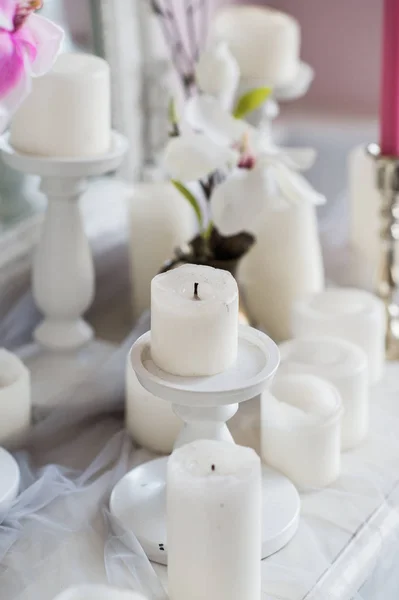 Diseño interior de habitación blanca con hermosas flores en la mesa servida. Gran espejo clásico creativo en el fondo . —  Fotos de Stock