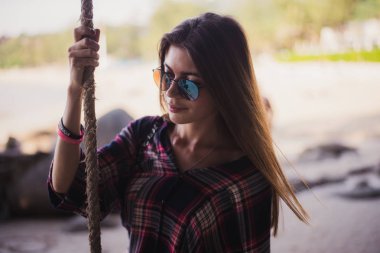 Sevimli kız sahilde poz. O bir ip ve uzakta arıyorum sahiptir. Bir moda mağaza için mükemmel fotoğraf