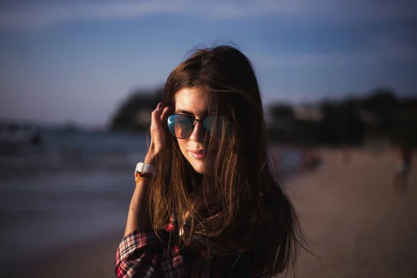 Primer plano retrato de dama delgada en camiseta rosa y gafas de sol cerca de piedra grande en la playa de roca mar mar orilla . — Foto de Stock