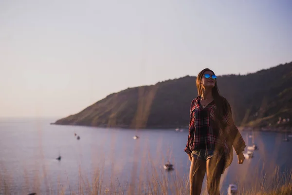 Хипстерская стильная женщина смотрит на море или океан на закате — стоковое фото