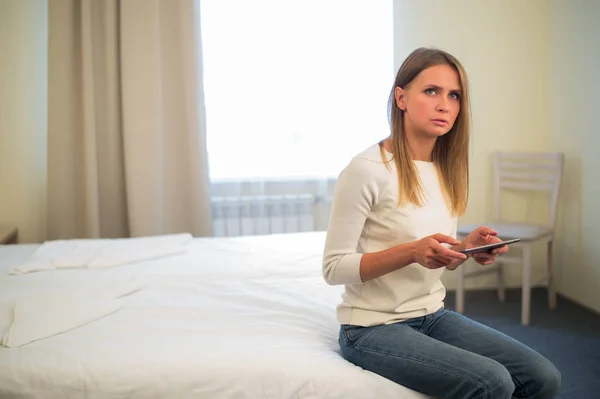 Young smiling woman sitting in the bed at home and connecting with a tablet, relax and leisure concept — Stock Photo, Image