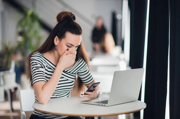 Communication technology. Sad upset girl unhappy woman sitting at the table in a cafe with mobile phone smartphone, reading sms. — Stock Photo, Image