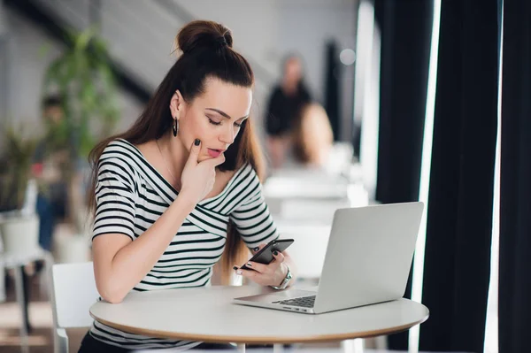 Ejecutivo preocupado hablando por teléfono tratando de resolver problemas con múltiples dispositivos sentados en un escritorio en la cafetería . — Foto de Stock