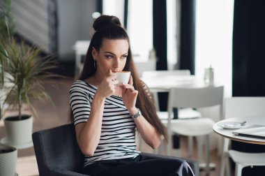 Pencere oturmak ve bir kahve bir fincan bir restoranda tatmak bir kadın portresi kapatın.