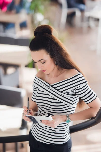 Retrato de una joven mujer de negocios en la oficina tomando notas sobre sus subordinados . — Foto de Stock