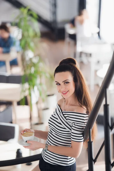 成年的美丽女性，站在那儿，cuppuccino 一杯，看着照相机的图片. — 图库照片