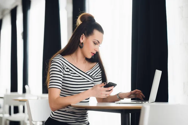 Mulher adulta ocupada trabalhando com smartphone e laptop durante sua única pausa para o almoço . — Fotografia de Stock