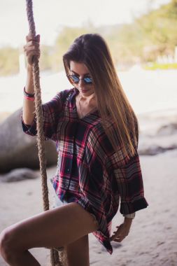 Sevimli kız sahilde poz. O bir ip ve uzakta arıyorum sahiptir. Bir moda mağaza için mükemmel fotoğraf