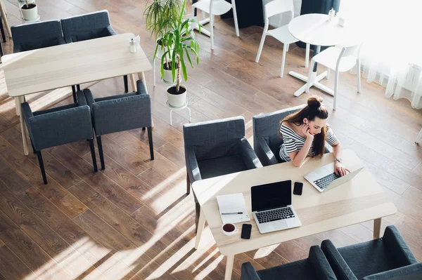 Raslantı onu laptop bir kafede üzerinde çalışan genç kadın. Bir fincan kahve iş yerinde oturuyor sıkılmış çekici Bayan.