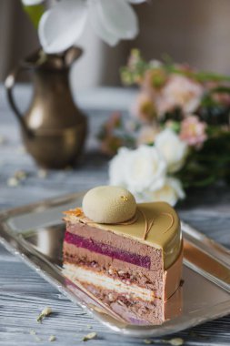 Badem dacquoise, ahududu confit, karamelize fındık ve ahududu toz, bitter çikolata üzerinde ahşap servis dayalı Mus gevrek katmanla alışılmadık sarı mousse kek parçası ile fırın