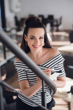 Sağlıklı saf deri ve doğal makyaj kameraya bakarak çekici gülümseyen kadın.