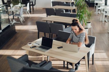 Farklı dizüstü bilgisayarlarda ama aynı masada aynı kafede coworking iki mutlu iş kadınları.