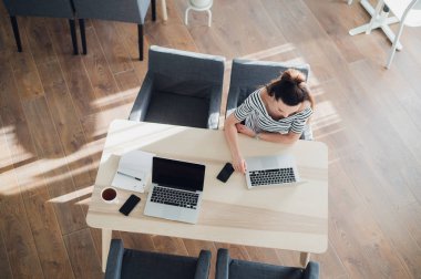 İki kadın bir kafede dizüstü bilgisayarlar ve smatphones ile aynı masada çalışma Üstten Görünüm.