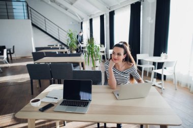 Güzel iş kadını ise bir ortak çalışma alanı toplantısı için bekleyen ve Taşınabilir bilgisayarınızla birlikte oturan bir kenara arıyor. Yetişkin kadın öğle yemeği sırasında bir dizüstü bilgisayarda web sörf.