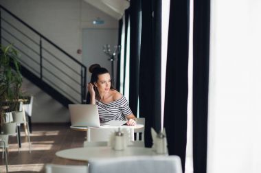 İlham arıyorsanız. Bazı notlar ve onun çalışma evinde sandalyede otururken pencereden bakarak genç güzel dalgın kadın.