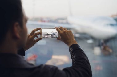 Adam elini al resmini uçak cep telefonu kullanarak. Turizm kavramı fotoğraf