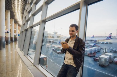 Yürüme ve hareket eden telefon arayan çekici bir genç adam portresi