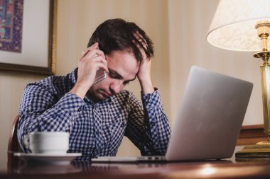 dizüstü bilgisayar ve bir iş yaptığı telefon, işadamı ofis ya da ev ara sahip kahve yorgun adam