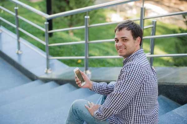 Люди, стиль, технології та спосіб життя - молодий чоловік зі смартфоном, що сидить на сходах міста — стокове фото