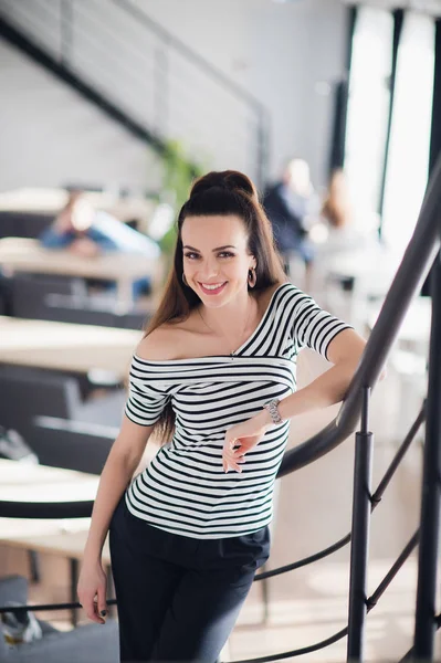Feliz mujer de negocios adulta de pie en un café y sonriendo mientras mira a la cámara . — Foto de Stock