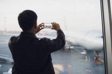 Gezgin emrini uçaklarına Havaalanı alarak resmi cep telefonu ile. Hava trafik kontrol olanakları arka plan