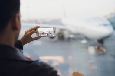 Gezgin emrini uçaklarına Havaalanı alarak resmi cep telefonu ile. Hava trafik kontrol olanakları arka plan