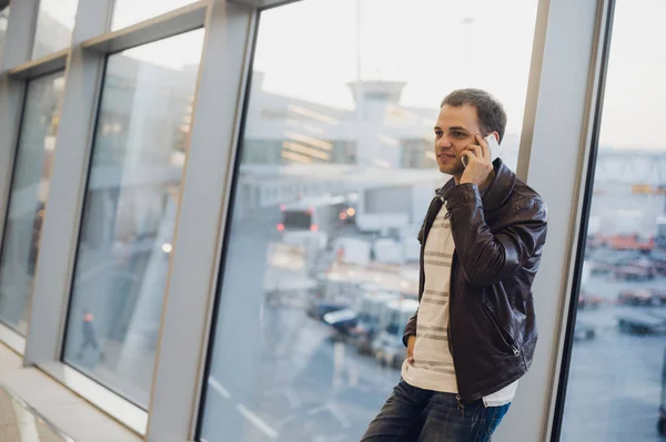 Бизнесмен разговаривает по телефону в терминале аэропорта — стоковое фото