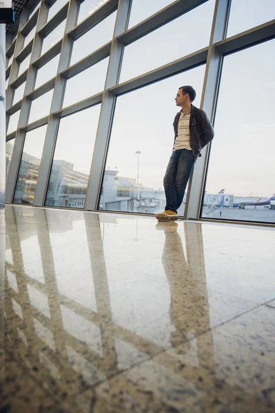 Kommer att bli hem snart. Porträtt av en stilig ung man skrattar talar på telefonen medan du väntar hans flyg på flygplatslounge — Stockfoto