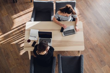 başlangıç iş ve genç çift yeni yaratıcı proje üzerinde dizüstü ve tablet bilgisayarda modern parlak ofis iç çalışma ve beyin fırtınası ile yeni mobil teknoloji kavramı, hava üst görüntüleme.