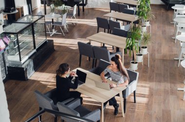 Bir kafede gülümseyen, dedikodu, kahve içme iki kız.