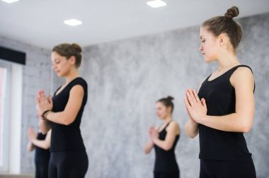 kadın eğitmen sınıf ayakta namaste ile poz yoga dersinde