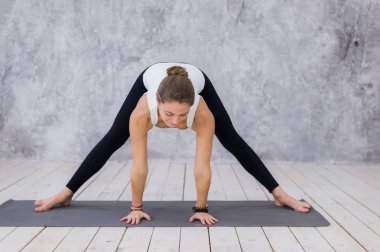 Bacaklar, yoga sınıf germe sportif genç bir kız. Sicim içinde oturan sarışın kadın