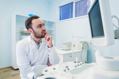 Tıbbi ekipman sceen yakınındaki bir düşünme doktor portresi.