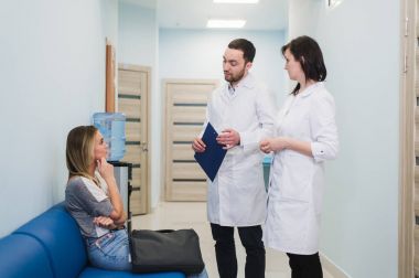 Female Patient Being Reassured By Doctors In Hospital Room clipart