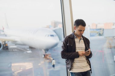 Genç iş adamı havaalanında smartphone kullanarak .