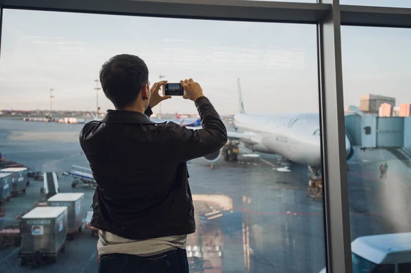 남자 손에 핸드폰을 사용 하 여 비행기의 사진을 가져가 라. 관광 개념 사진 — 스톡 사진