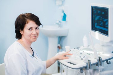 Ultrason tarayıcı kullanarak mutlu olgun kadın doktor. Echography makine